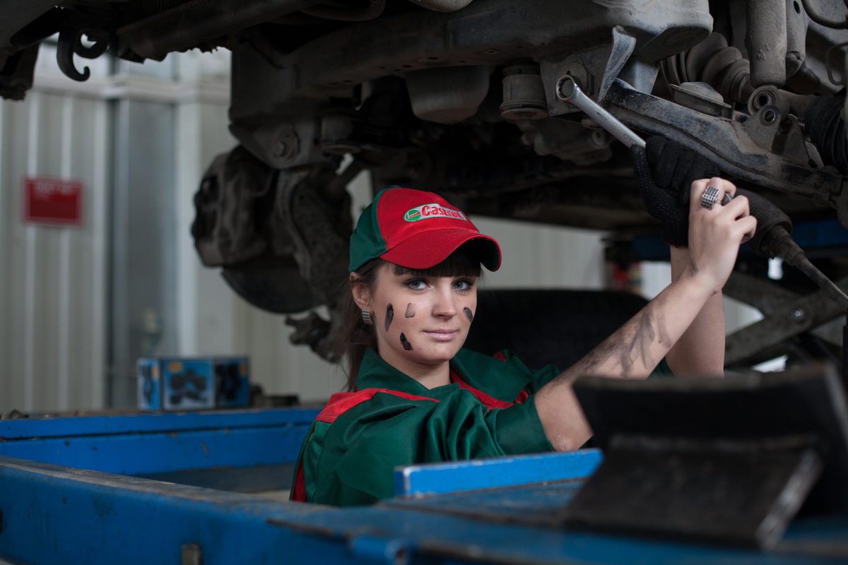 Técnica trabajando en mantenimiento automotriz